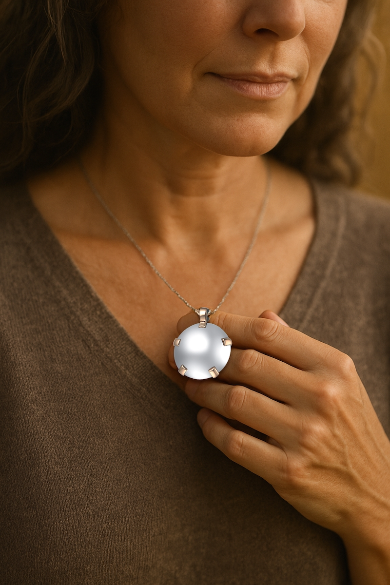 Woman gently holding BioElectric Shield pendant at her chest